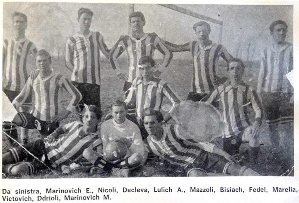2 - moštvo Tržiča l.1914;  kot lahko razberemo po postavi, je bilo najbrž kar nekaj fantov slovenskega oz. slovanskega (hrvaškega) porekla: Marjanovič E. In M., Dekleva, Lulič, Bizjak, Viktovič. Najbrž so bili zaposleni v ladjedelnici.